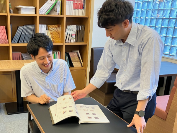カタログを見ながら自社商品を提案する社員